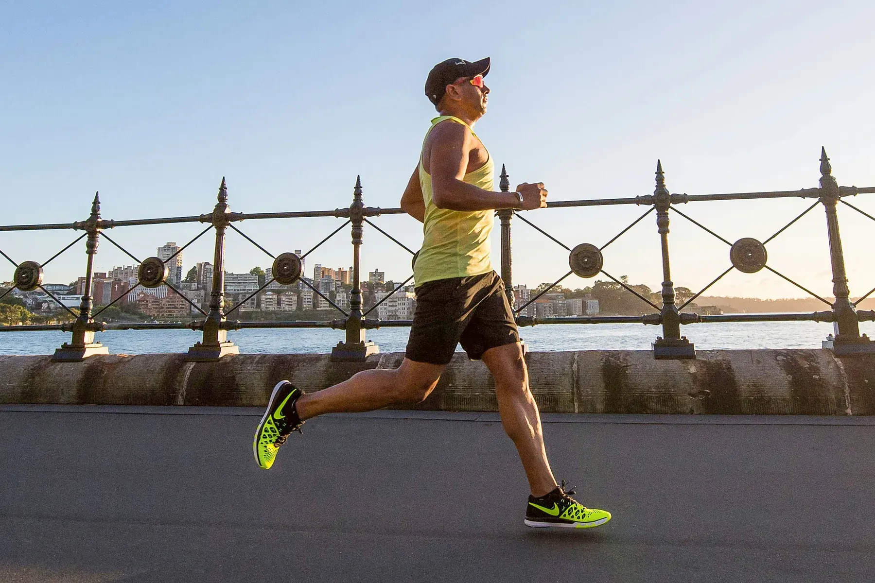Un hombre corre junto al puerto a primera hora, con el sol saliendo
